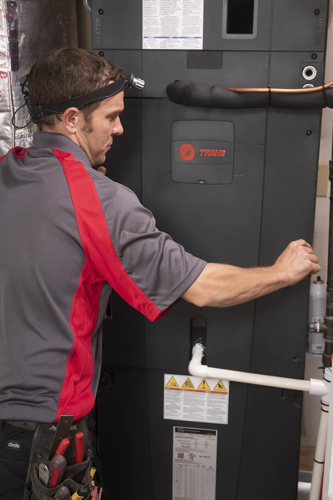 HVAC Service Tech working on furnace front panel at air handler